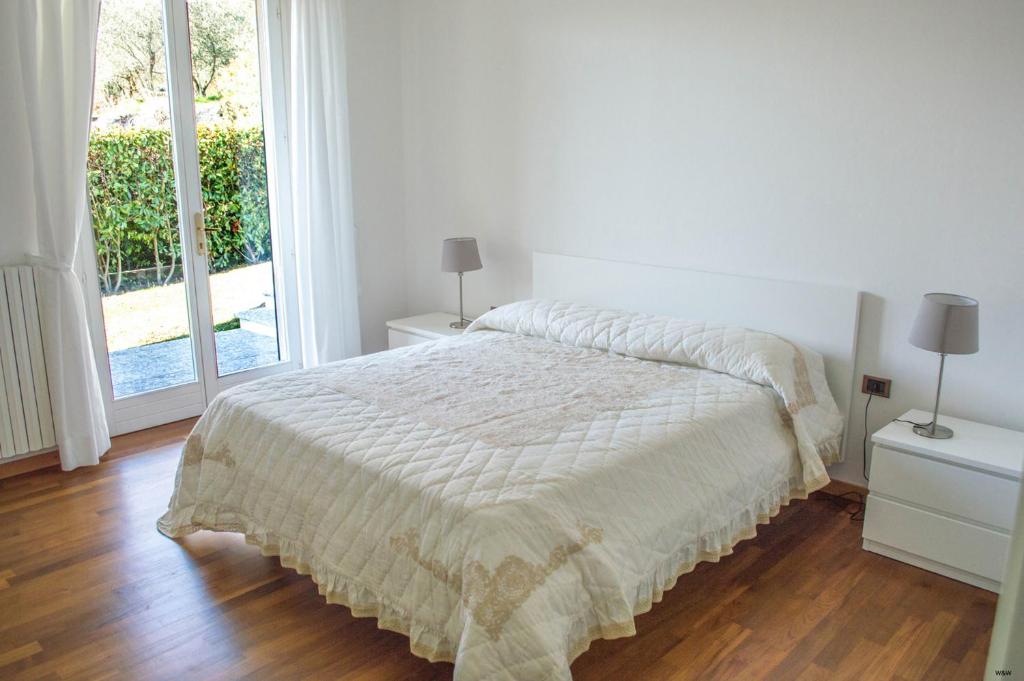 une chambre blanche avec un lit et une grande fenêtre dans l'établissement Villa Oliva, à Tremezzo 35 autres photos