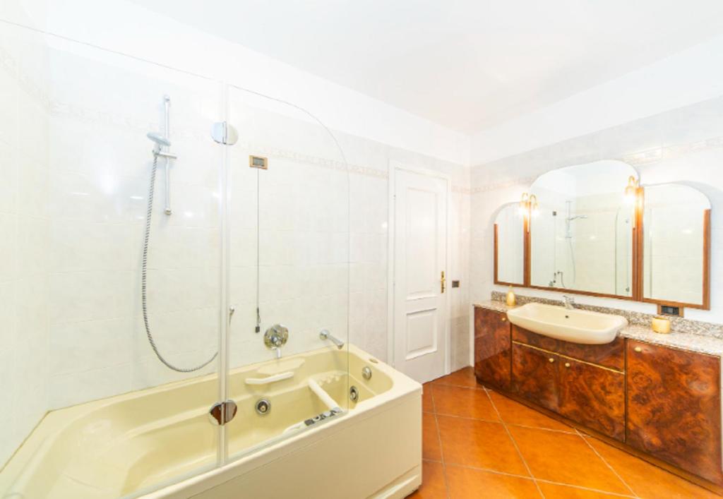 une salle de bain avec une baignoire et un lavabo dans l'établissement Villa Oliva, à Tremezzo