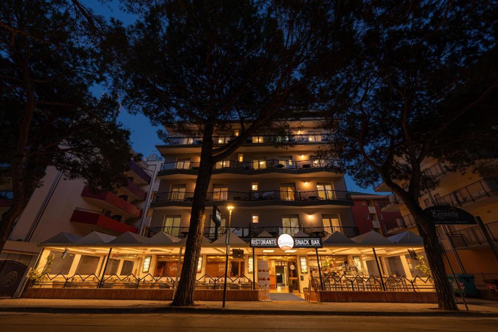un grand bâtiment avec des lumières devant lui la nuit dans l'établissement Hotel Kennedy, à Lido di Jesolo
