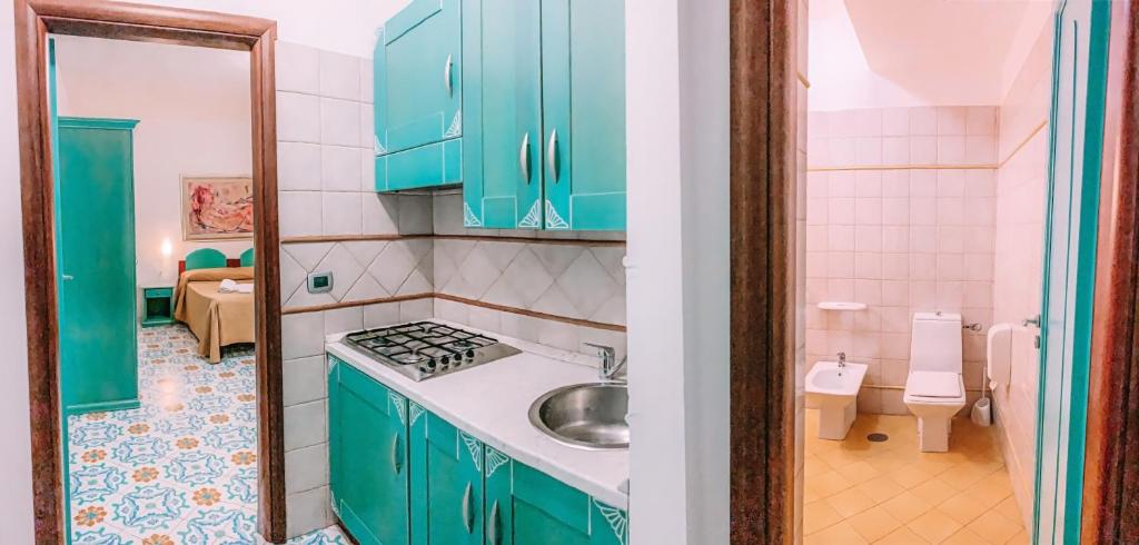 une cuisine avec des armoires bleues et un évier dans l'établissement Residence Antigua, à Bonifati