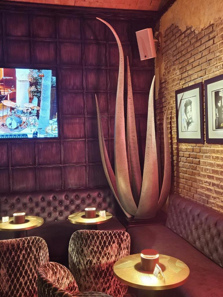 un restaurant avec deux tables et chaises et un écran dans l'établissement Riad Monceau, à Marrakech