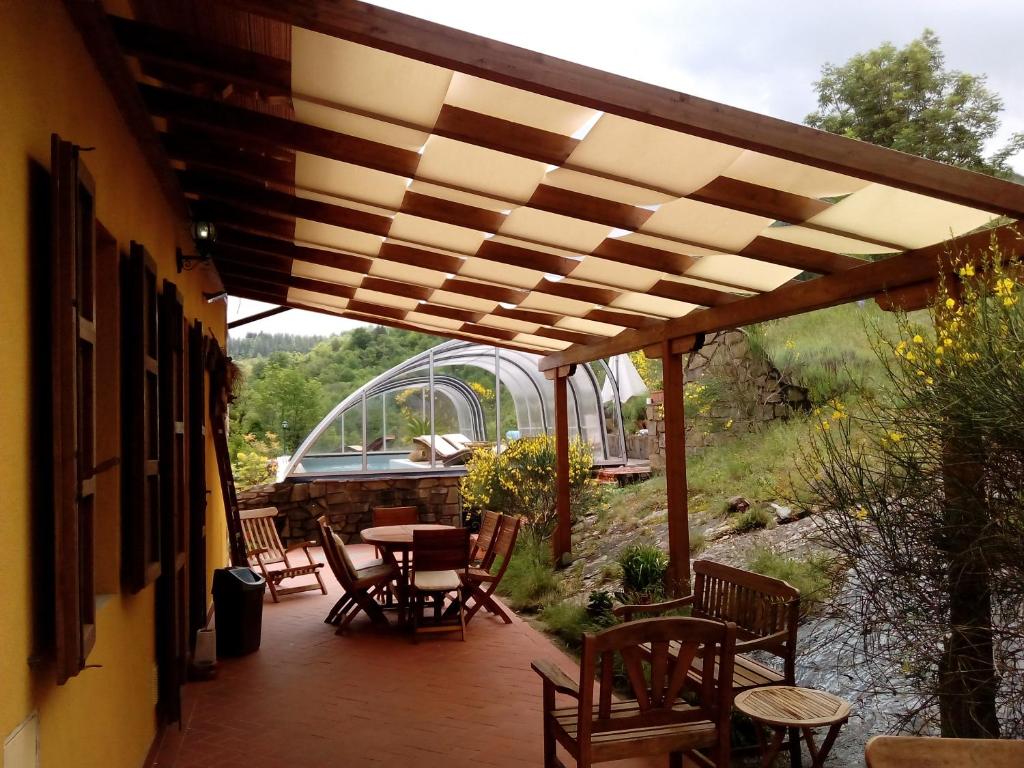 une terrasse avec des chaises et des tables ainsi qu'une pergola en bois. dans l'établissement DeiMori LaMassa private villa with pool, à Castel San Niccolò
