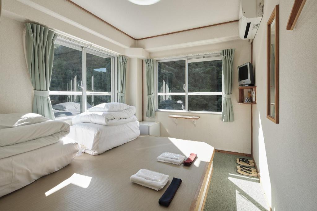 une chambre d'hôtel avec deux lits et une fenêtre dans l'établissement Sansuikan Kawayu Matsuya, à Hongu 28 autres photos