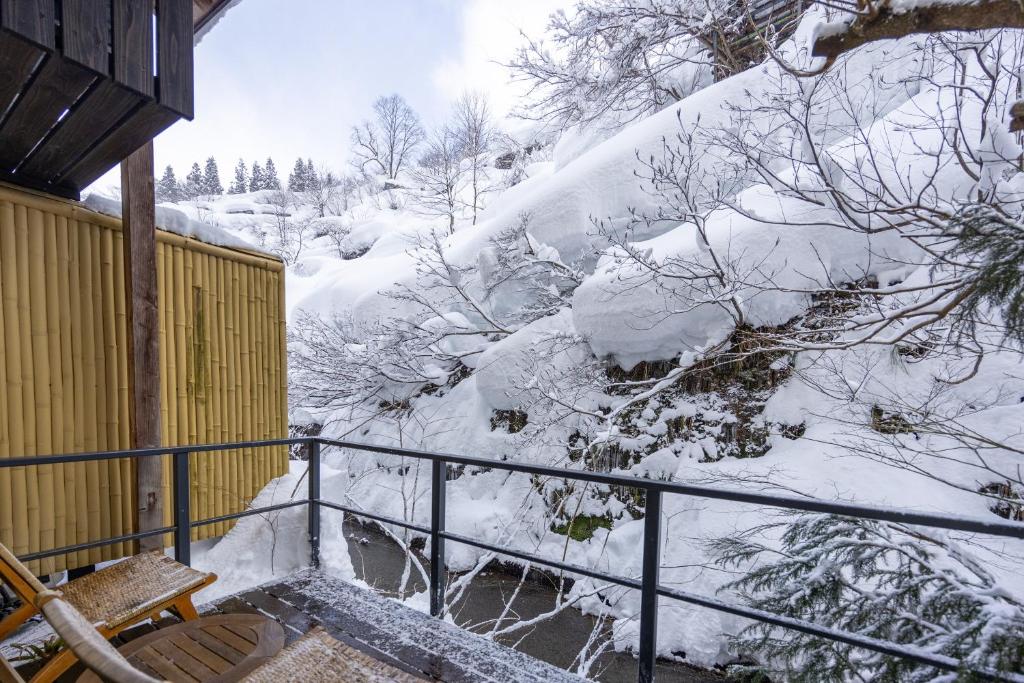 un escalier enneigé avec une montagne enneigée dans l'établissement Sake Hotel Tamakiya, à Tōkamachi