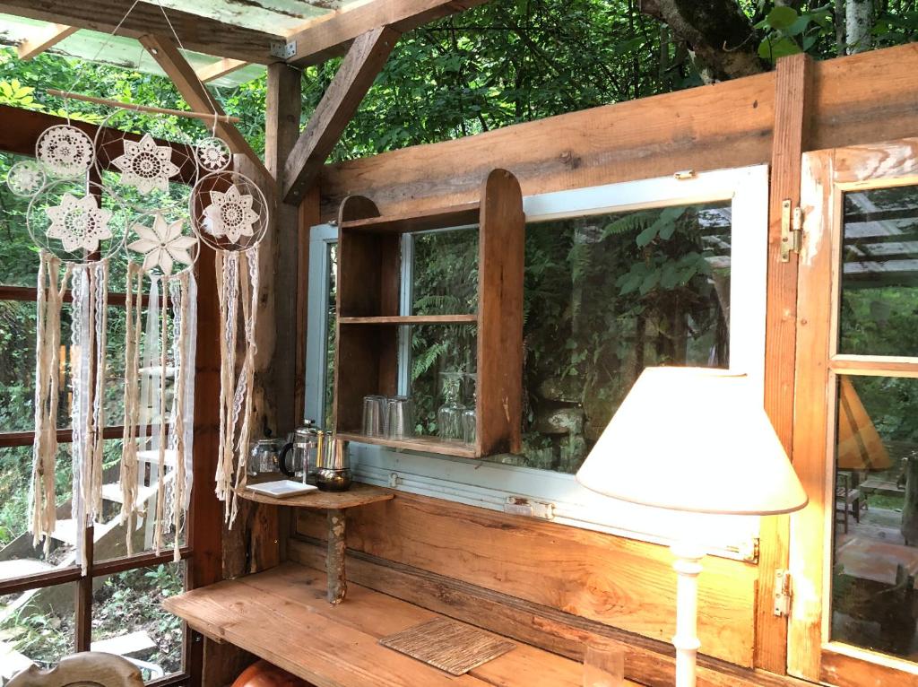 une fenêtre dans une maison en bois avec une lampe dans l'établissement Yourte dans la forêt, à Rennes-les-Bains 7 autres photos