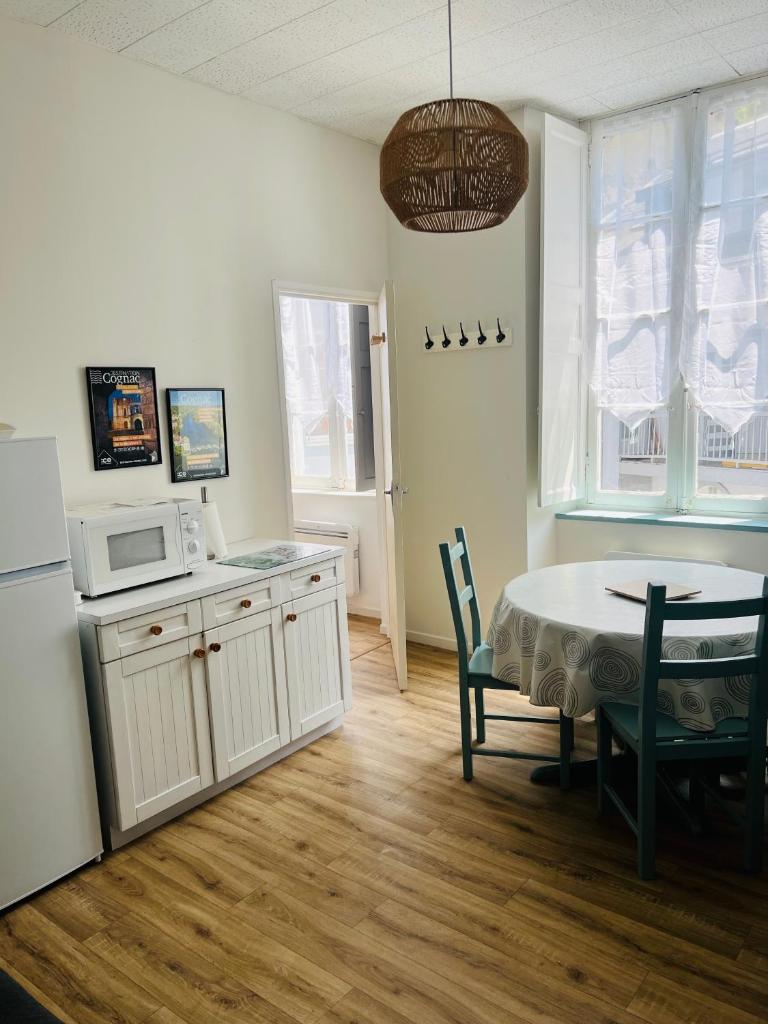 - une cuisine et une salle à manger avec une table et un four micro-ondes dans l'établissement 11 Rue de Richelieu, à Cauterets