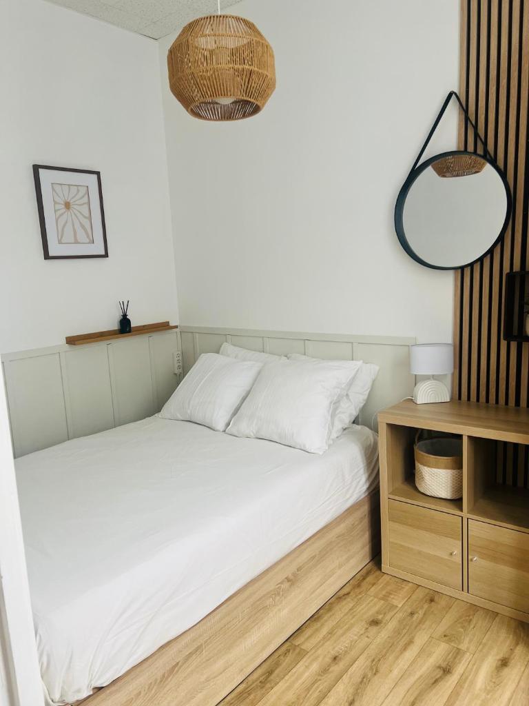 une chambre avec un lit blanc et une table de chevet dans l'établissement 11 Rue de Richelieu, à Cauterets