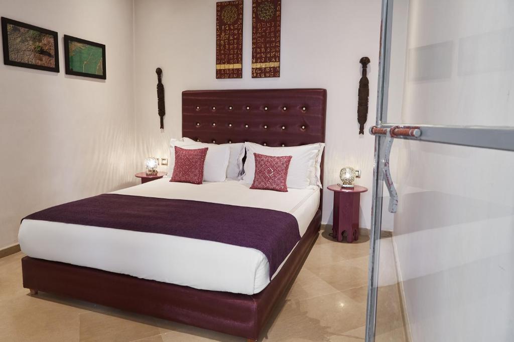 une chambre avec un grand lit avec des oreillers rouges dans l'établissement Riad Infinity Sea, à Marrakech