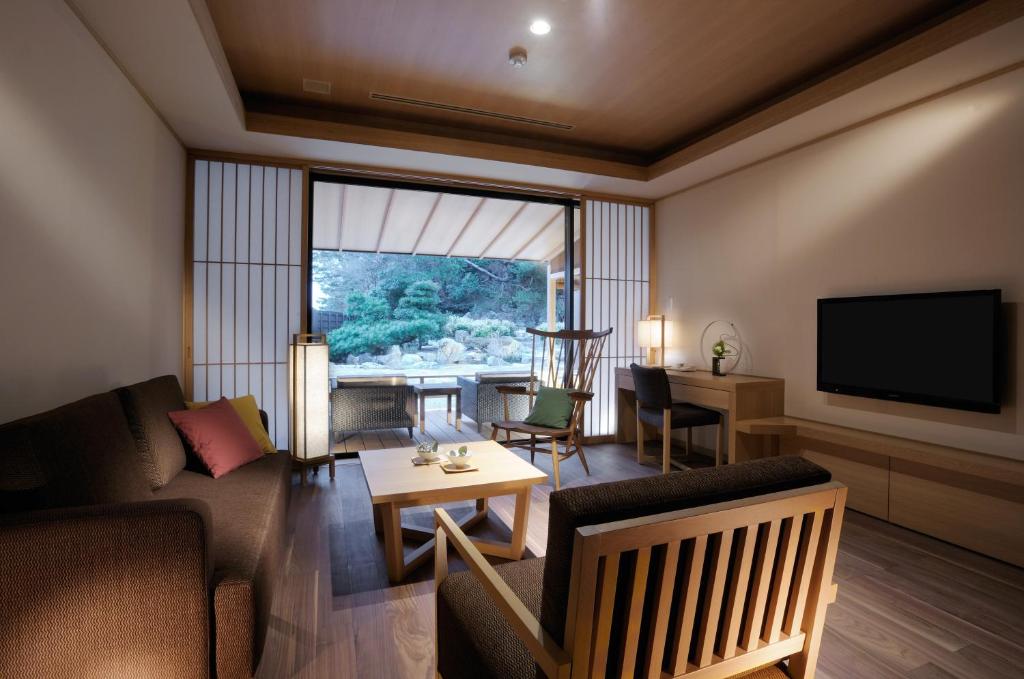 un salon avec un canapé et une télévision dans l'établissement Toba International Hotel Shiojitei, à Toba