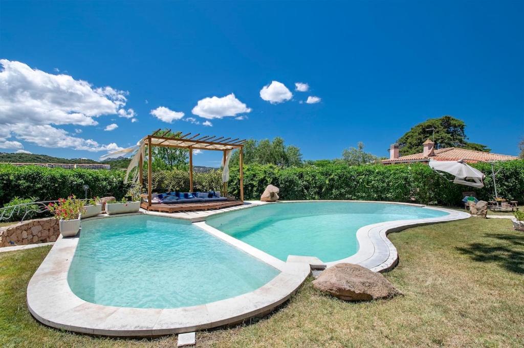 une grande piscine dans une cour dans l'établissement Villa con piscina e giardino, à Cala Bitta