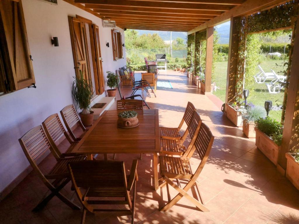 un patio avec une table et des chaises en bois dans l'établissement New entire villa with pool and sea views, à Santa Domenica Talao
