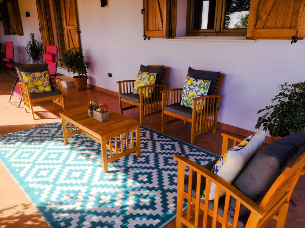 - un salon avec des chaises, des tables et un tapis dans l'établissement New entire villa with pool and sea views, à Santa Domenica Talao