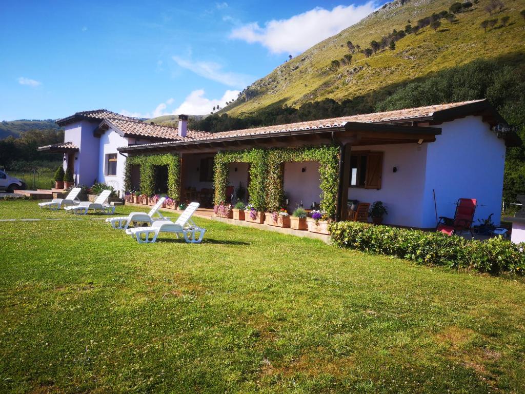une maison avec un groupe de chaises dans la cour dans l'établissement New entire villa with pool and sea views, à Santa Domenica Talao