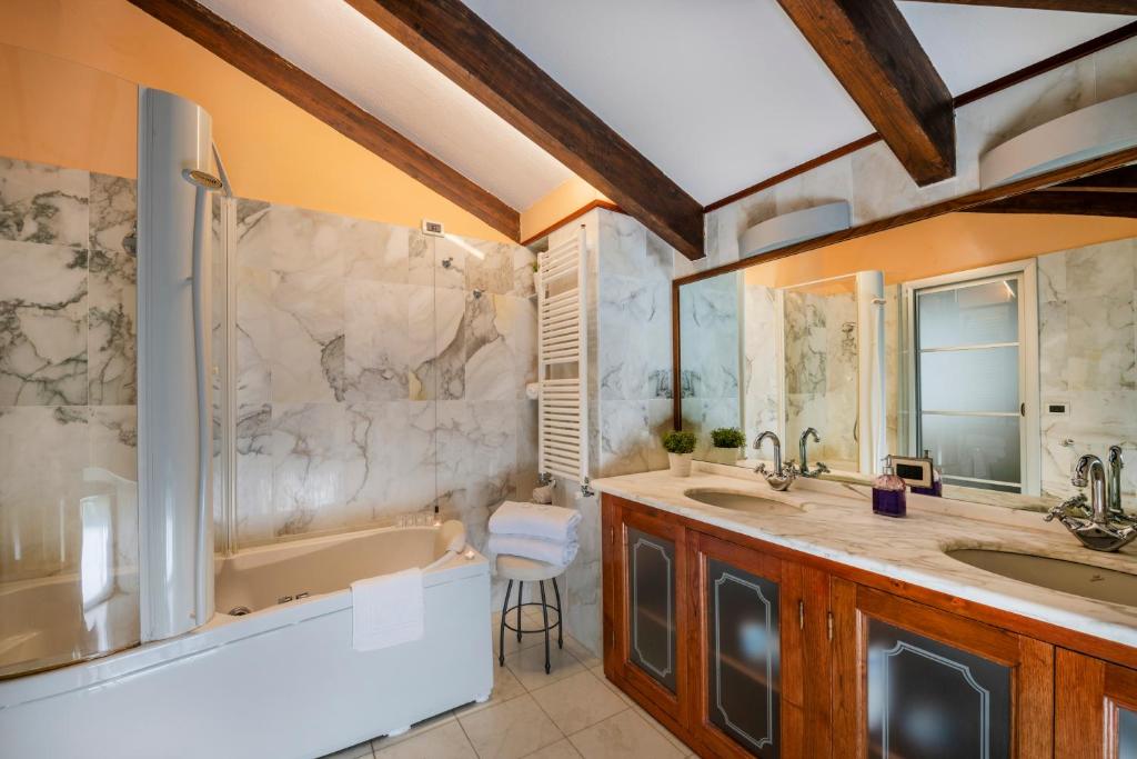 une salle de bain avec deux lavabos, une baignoire et une douche dans l'établissement Villa Le Palme Swimming-Pool & Relax in the Gulf of Poets, à La Spezia