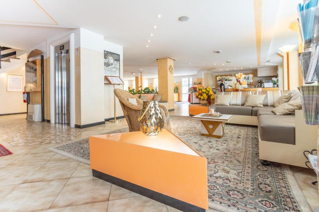 un salon avec un canapé et une table dans l'établissement Hotel Helios, à Rimini