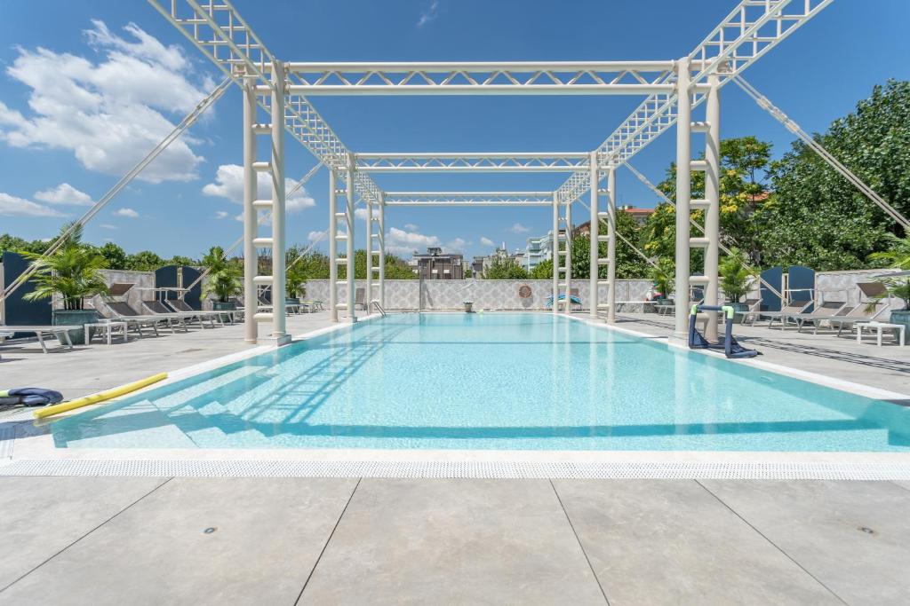 une grande piscine à structure métallique dans l'établissement Hotel Helios, à Rimini