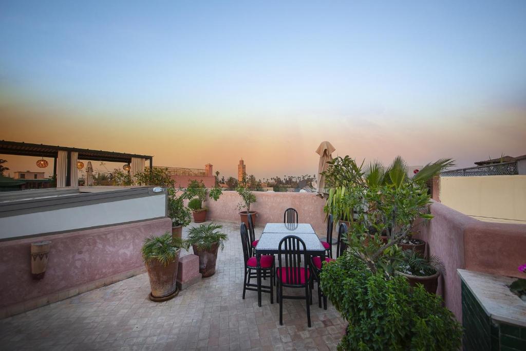un patio avec une table, des chaises et des plantes dans l'établissement Riad Atrium & Spa, à Marrakech