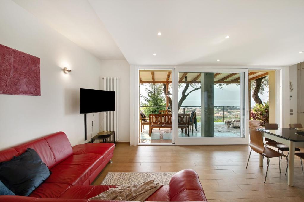un salon avec un canapé rouge et une table dans l'établissement Villa Savi Lake View and Pool, à Torri del Benaco