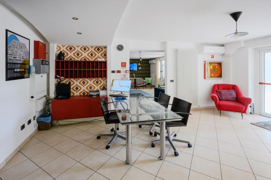 un bureau avec une table en verre et une chaise rouge dans l'établissement Residence l'Appartamento, à Rimini
