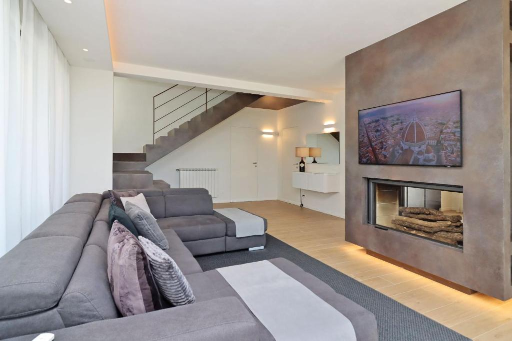 un salon avec un canapé et une cheminée dans l'établissement Villa Poggio ai Sassi-Private Villa & Pool, à Reggello