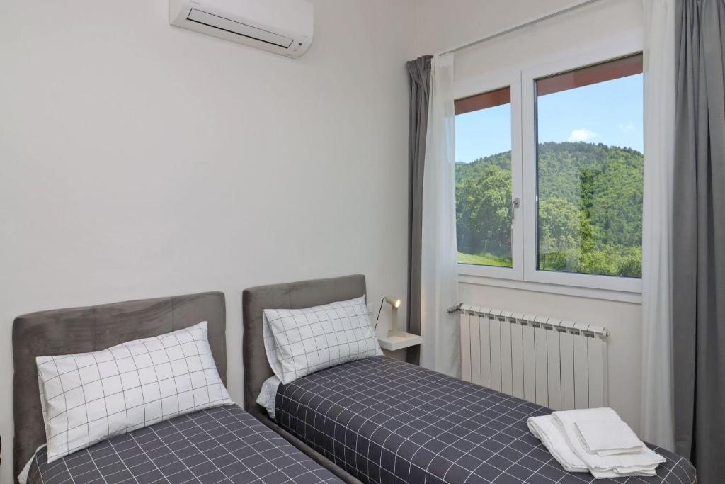 une chambre avec deux lits et une fenêtre dans l'établissement Villa Poggio ai Sassi-Private Villa & Pool, à Reggello