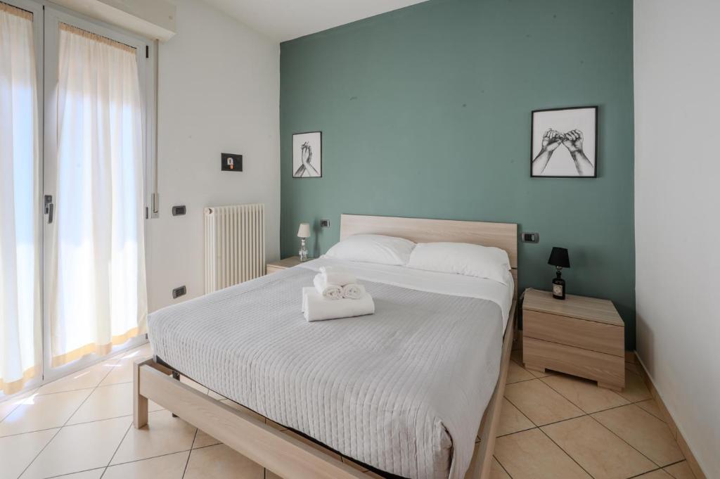 - une chambre avec un lit blanc et une serviette blanche dans l'établissement Residence l'Appartamento, à Rimini