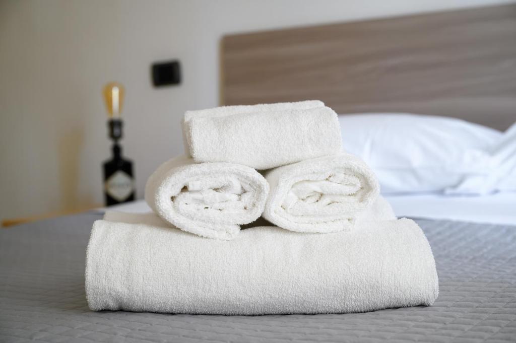 - une pile de serviettes assises sur un lit dans l'établissement Residence l'Appartamento, à Rimini