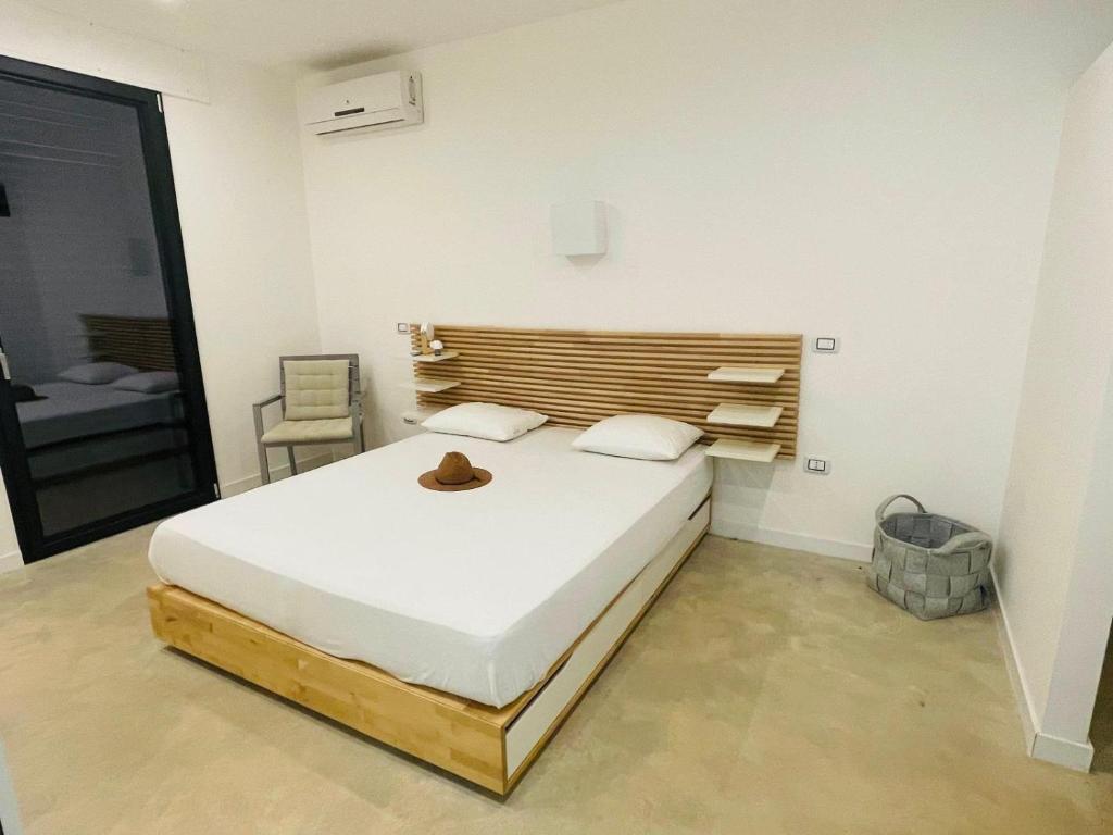 une chambre avec un grand lit avec une tête de lit en bois dans l'établissement Villa degli Ulivi, à Torre Vado