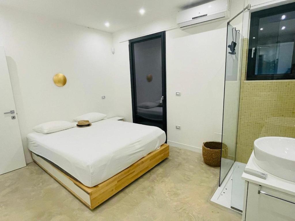 une chambre avec un lit et une salle de bain avec un lavabo dans l'établissement Villa degli Ulivi, à Torre Vado