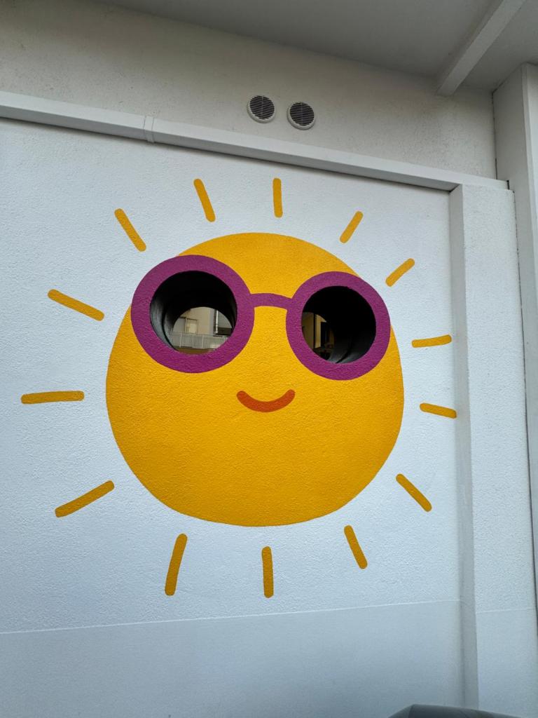 une porte avec un visage de soleil avec des lunettes de soleil dans l'établissement Regina Urban Beach Hotel, à Lido di Jesolo