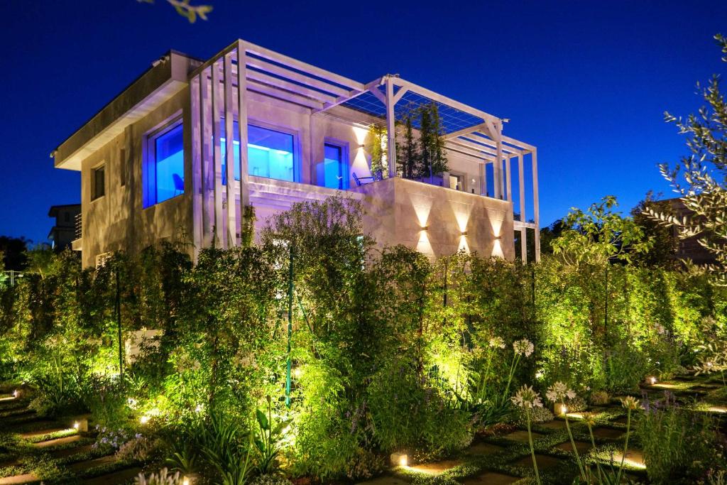 une maison avec des lumières bleues dans un jardin dans l'établissement Villa con piscina e SPA nel Salento Alternative Relax, à Scorrano
