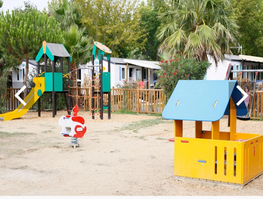 une aire de jeux avec plusieurs structures de jeux dans le sable dans l'établissement Mobil home prémium 8 pers camping 4 étoiles, à Saint-Cyprien