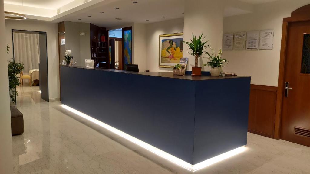 un hall d'accueil avec un bureau de réception éclairé dans l'établissement Hotel Il Caminetto, à Porto San Giorgio
