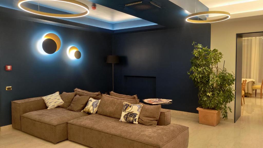 un salon avec un canapé et un mur bleu dans l'établissement Hotel Il Caminetto, à Porto San Giorgio