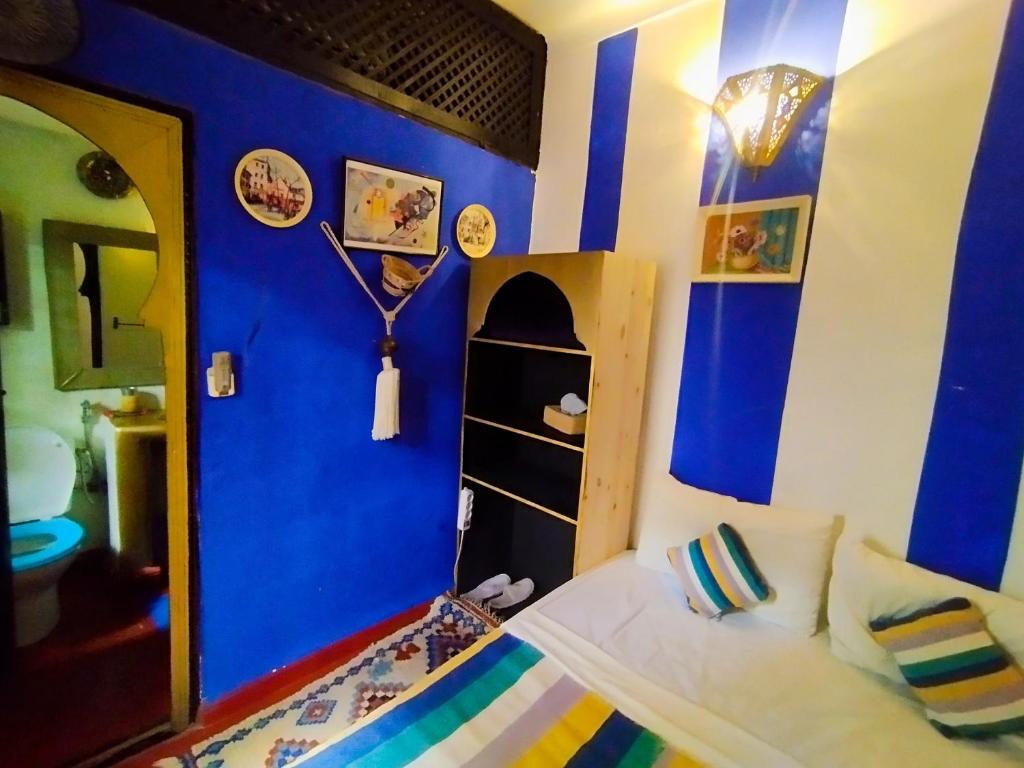 - une chambre aux murs bleus et un lit dans un dortoir dans l'établissement riad cherif, à Marrakech