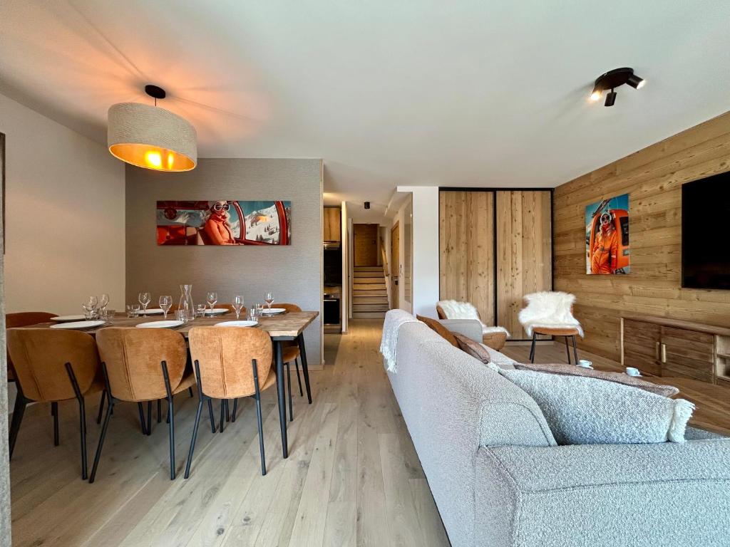 une salle à manger avec une table et un canapé dans l'établissement Homency - Résidence L'Expression B12, à L'Alpe-d'Huez