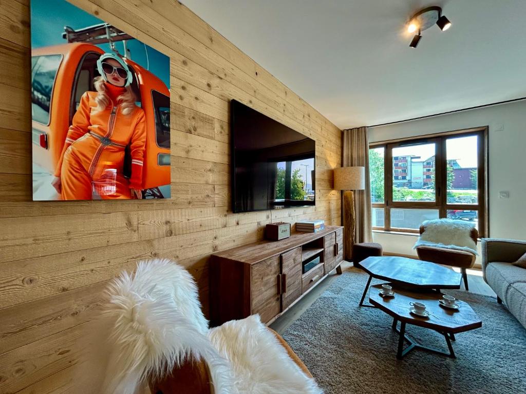 - un salon avec une télévision à écran plat sur un mur en bois dans l'établissement Homency - Résidence L'Expression B12, à L'Alpe-d'Huez