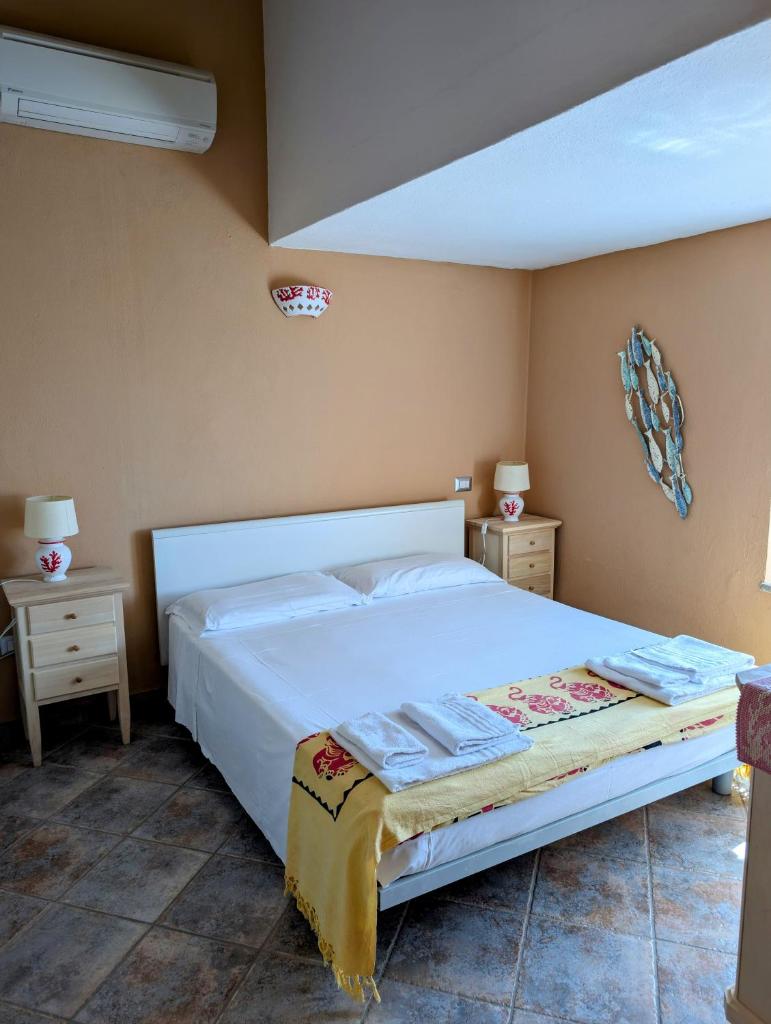 - une chambre avec un lit blanc et 2 tables de chevet dans l'établissement Capo Ceraso Family Resort, à Costa Corallina