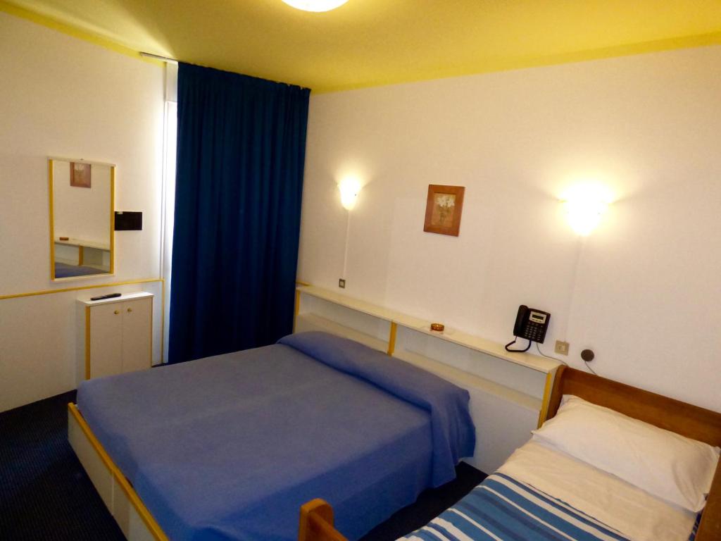 une chambre d'hôtel avec deux lits et une fenêtre dans l'établissement Mon Repos, à Lido di Jesolo