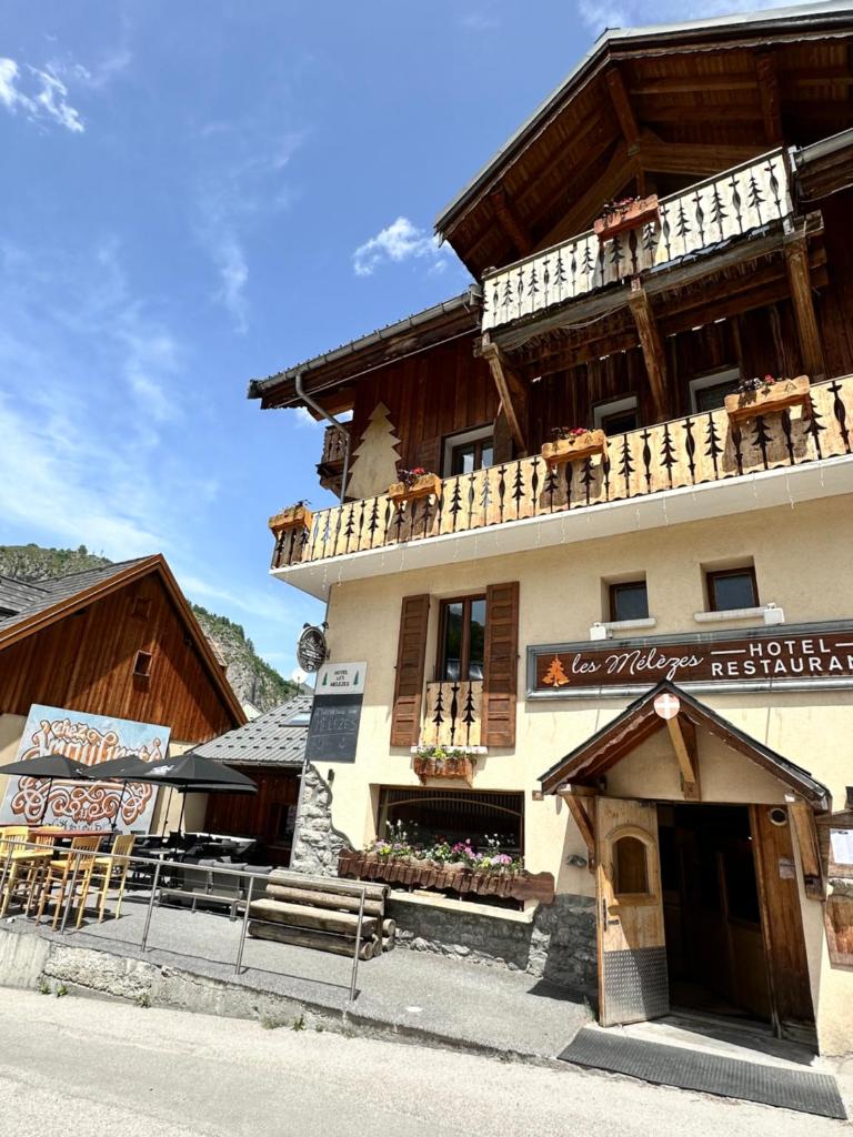 Un grand bâtiment avec un balcon est à votre disposition. dans l'établissement Hôtel-Chalet les Mélèzes, à Valloire
