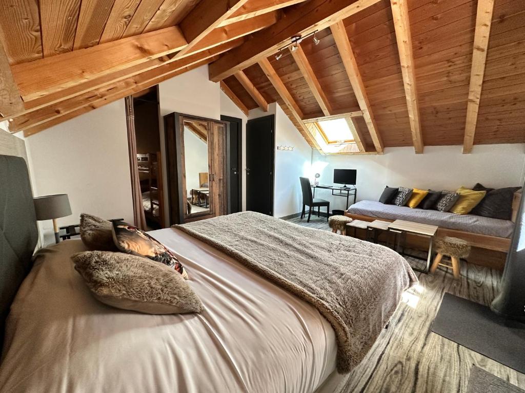 une chambre avec un grand lit et un canapé dans l'établissement Hôtel-Chalet les Mélèzes, à Valloire