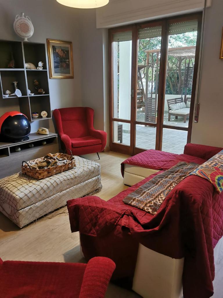 - un salon avec un lit et une chaise rouge dans l'établissement Dimora La Fenice, à Licola