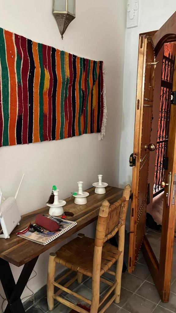 Cette chambre dispose d'une table en bois et d'un téléphone. dans l'établissement Riad EL BADI, à Marrakech
