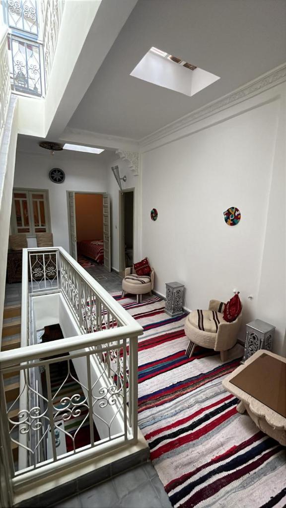 une chambre avec un escalier, des chaises et un canapé dans l'établissement Riad EL BADI, à Marrakech