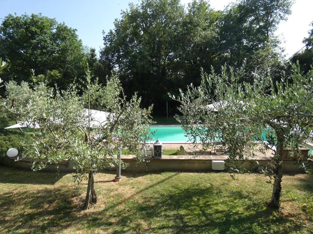 une cour avec des arbres et une piscine dans l'établissement Scappo in Umbria, villa Claudia, à Foligno