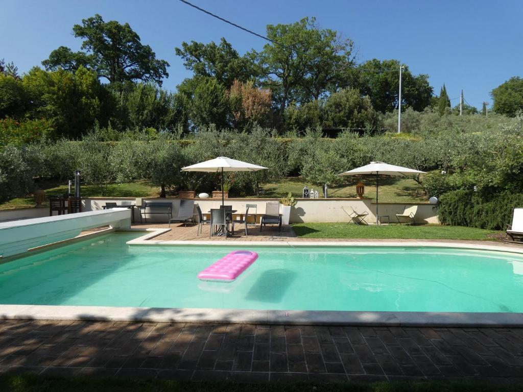 - une piscine avec un flotteur rose dans une cour dans l'établissement Scappo in Umbria, villa Claudia, à Foligno