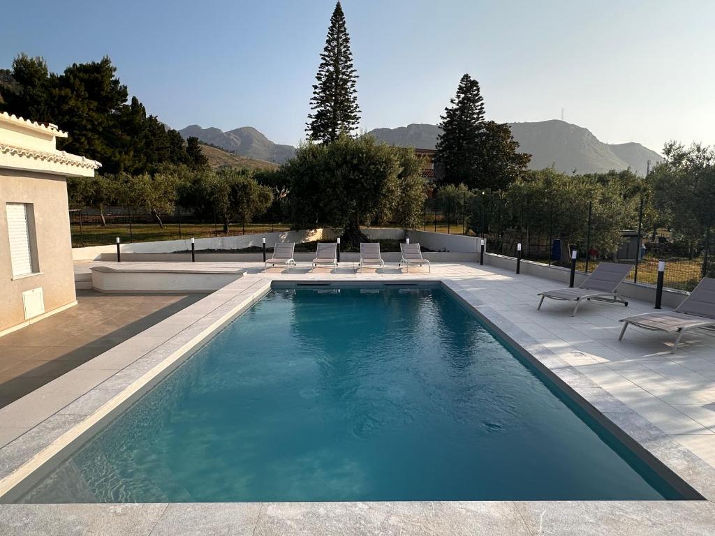 une grande piscine avec des chaises longues dans l'établissement Villa Valentina, à Altavilla Milicia