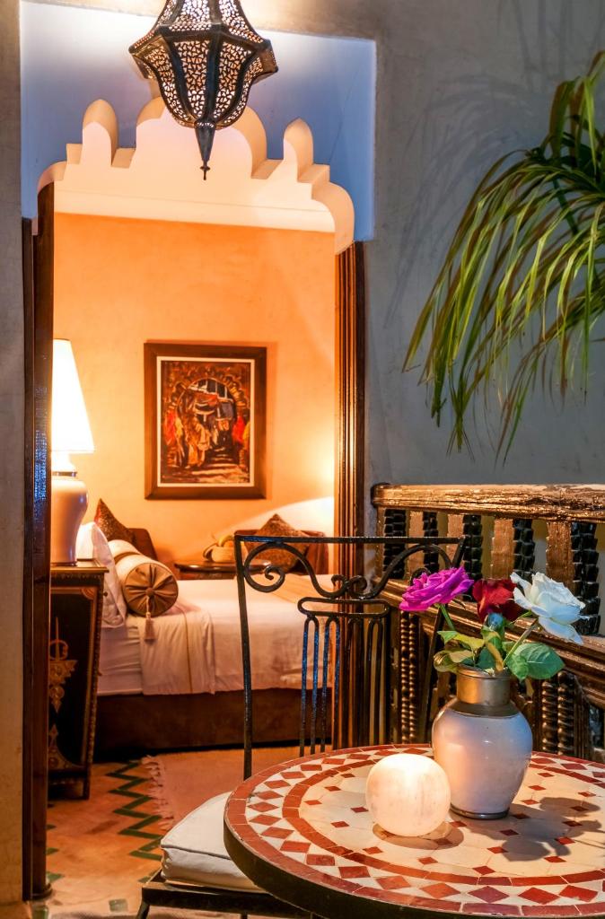 - une chambre avec un lit et une table fleurie dans l'établissement Riad Eden, à Marrakech