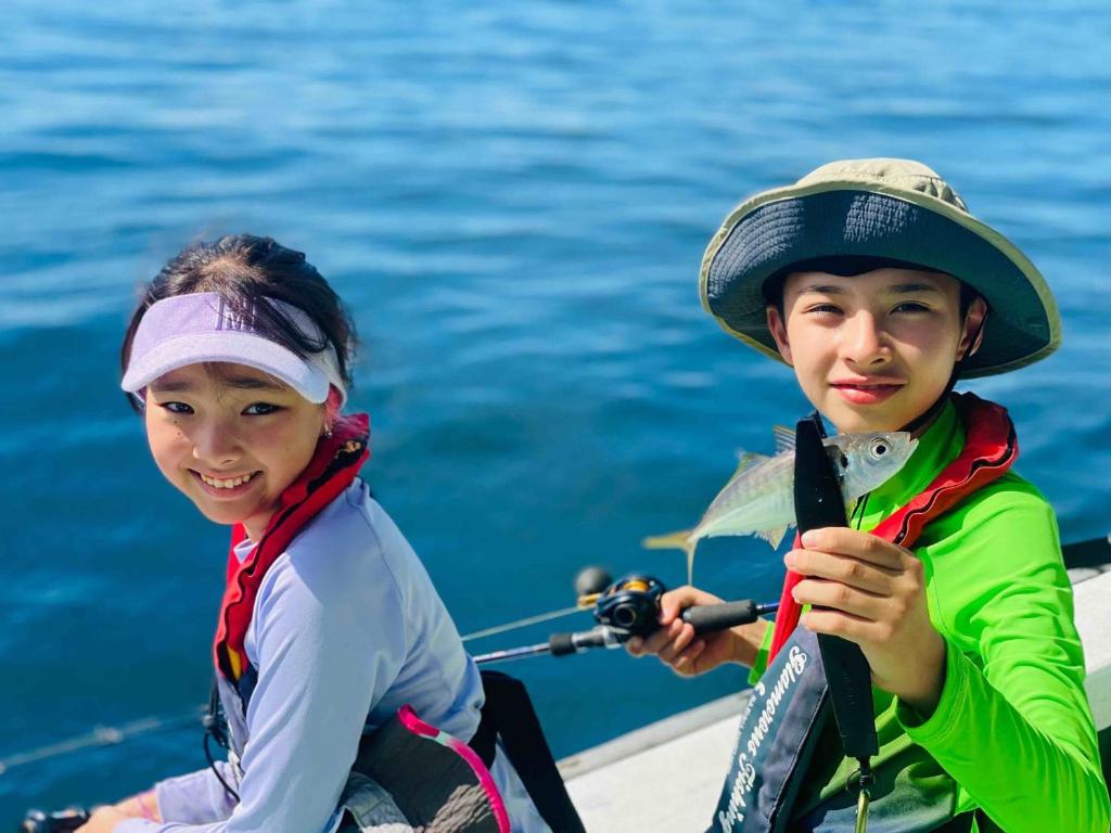 deux enfants sont assis sur un bateau dans l'eau dans l'établissement Awakan, à Sumoto