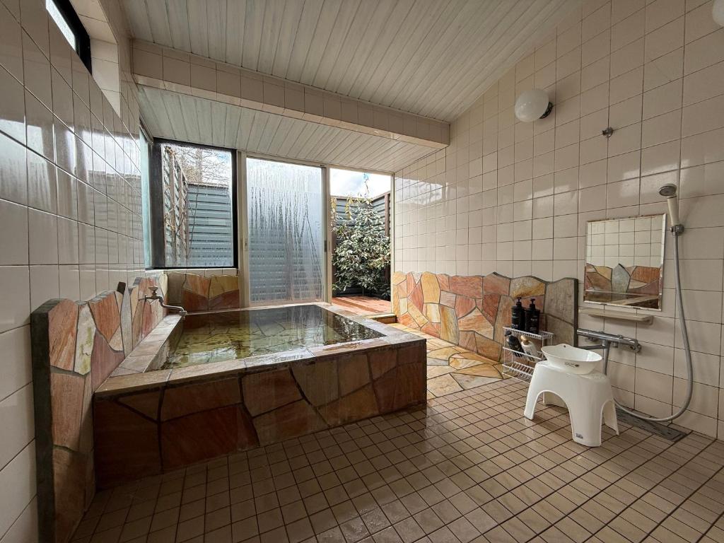La grande salle de bains est pourvue d'une baignoire et de toilettes. dans l'établissement Manor House, à Yamanakako
